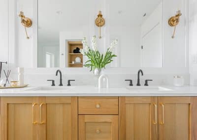 A bathroom with two faucets and a white marble sink made by home renovation contractors in Langley, BC