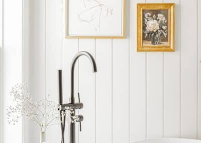 An image of a bathroom with a faucet and picture frames made by home renovation contractors in Langley, BC