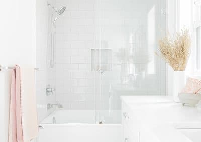 A picture of a bathroom with white countertop and a bathtub made by custom home builder Langley in Langley, BC