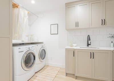 A picture of a laundry area with washing machines, cabinet made by a custom home builder langley in Langley, BC