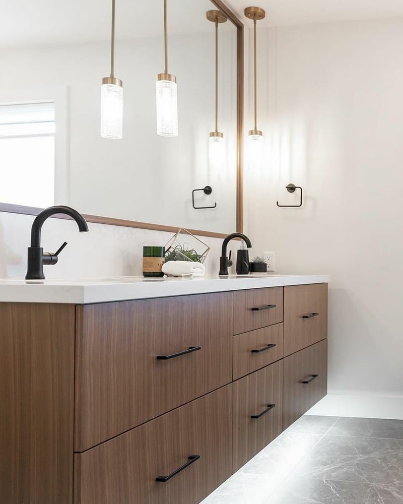 A renovated bathroom showcasing a rich brown cabinet with a modern black faucet by home renovation contractors in Langley, BC