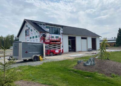 A white pole barn with a black roof, a testament to expert pole barn construction in Langley, BC