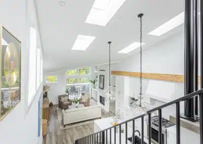 A white accent living room and kitchen with modern industrial kitchen equipment by kitchen renovation contractor in Langley, BC