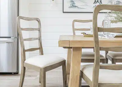 A white accent dining area with wooden tables and floors by renovation company in Langley, BC