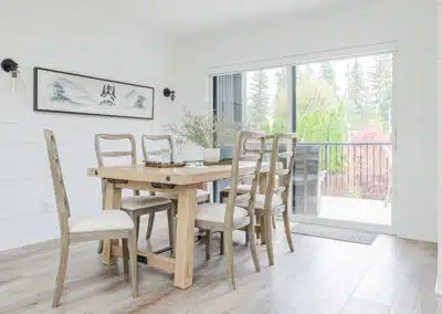 A white accent dining area with wooden tables and floors by renovation company in Langley, BC