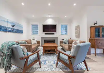 Cozy living room with a fireplace, comfortable seating, and a nautical theme by home renovation contractors in Langley.