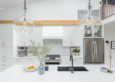 Modern kitchen with white cabinets, a large island, and plenty of natural light by design-build contractors in Langley