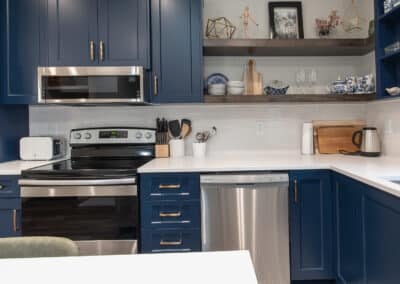 Stylish kitchen with navy blue cabinets and white countertops by home renovation contractors in Langley