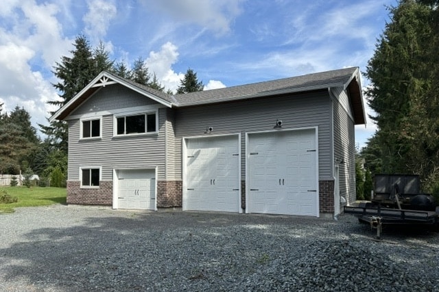 Spacious two-story house with a large garage and a gravel driveway. - Custom home builders, Langley