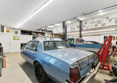 A large, well-lit outbuilding garage with a collection of classic cars by Bowline Construction in Langley, BC