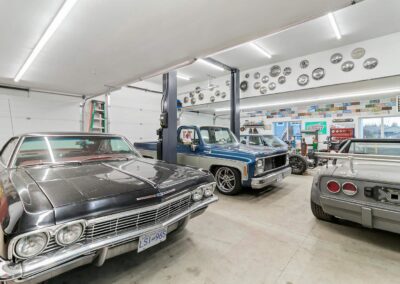 A large, well-lit outbuilding garage with a collection of classic cars by Bowline Construction in Langley, BC