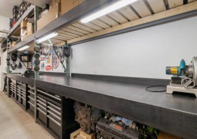 A well-organized workshop with a large workbench, tool cabinets, and shelves stocked with supplies in Langley, BC