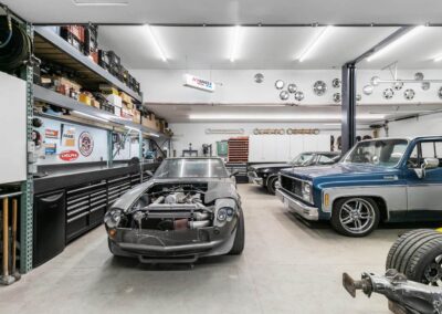 A well-equipped outbuilding garage with a classic car, shelves full of tools and supplies, and a workbench by Bowline Construction in Langley, BC