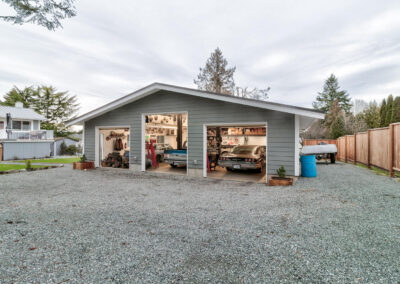 A large, detached garage outbuildings with two car bays and a gravel driveway by Bowline Construction in Langley, BC