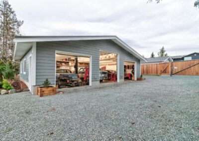 A large, detached garage outbuildings with two car bays and a gravel driveway by Bowline Construction in Langley, BC