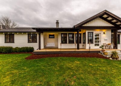 A one-story house with a covered porch, a swing, and a grassy yard