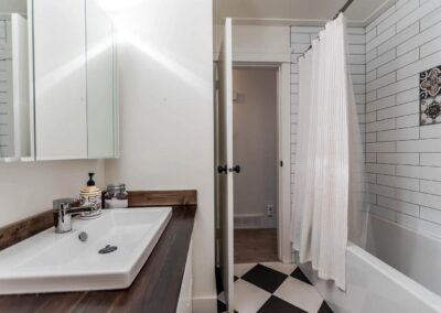 A bedroom with a bed, a brick accent wall, a white closet, and decorative shelves.