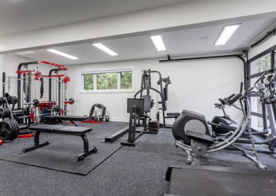 A well-equipped custom addition home gym with gray rubber flooring in Langley, BC