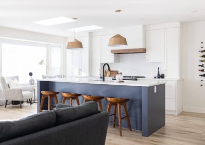 Contemporary kitchen featuring a blue island with seating, pendant lights, and skylights by Bowline Construction kitchen renovation contractor in Langley, BC