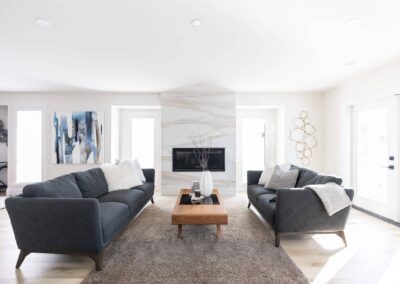 Contemporary living room with two gray sofas facing each other, a fireplace, and artwork by Bowline Construction design-build contractors in Langley, BC