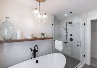 bathroom featuring a freestanding tub, a glass shower, and pendant lights by custom home builder langley, BC