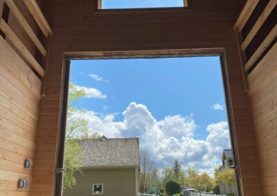 A large, open barn with a view of a clear blue sky and a green field in Langley, BC