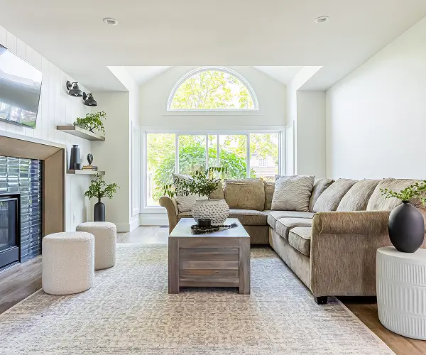 Custom home living room with large arched window and neutral furnishings by Bowline Construction in Langley, BC
