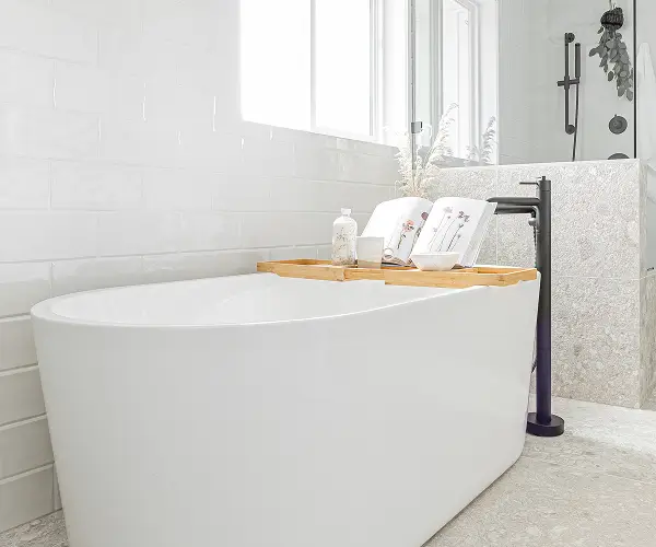 Custom bathroom with elegant freestanding tub and sunlit tile surround by Bowline Construction in Langley, BC