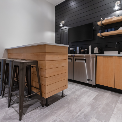Contemporary staff kitchen with wood and dark accents completed as part of a commercial tenant improvement by Bowline Construction in Langley, BC
