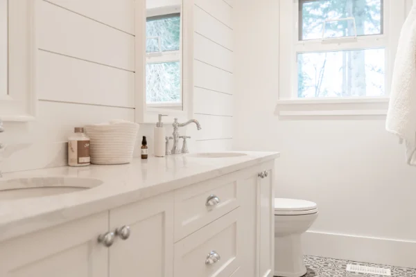 White bathroom with double vanity and marble countertops by Bowline Construction in Surrey, BC
