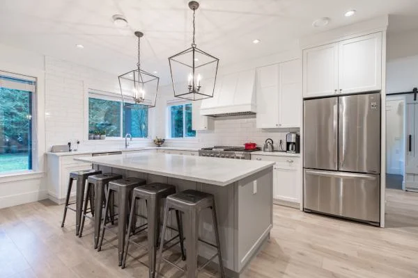 Contemporary kitchen renovation featuring large island, pendant lights, and stainless steel finishes by Bowline Construction in White Rock, BC