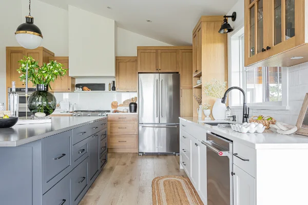 Renovated kitchen featuring wood cabinetry, island, and stainless steel appliances by Bowline Construction in Surrey, BC