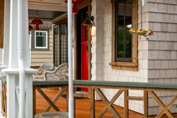 Beautifully crafted wooden porch with red front door designed for home renovations Abbotsford by Bowline Construction in Abbotsford, BC