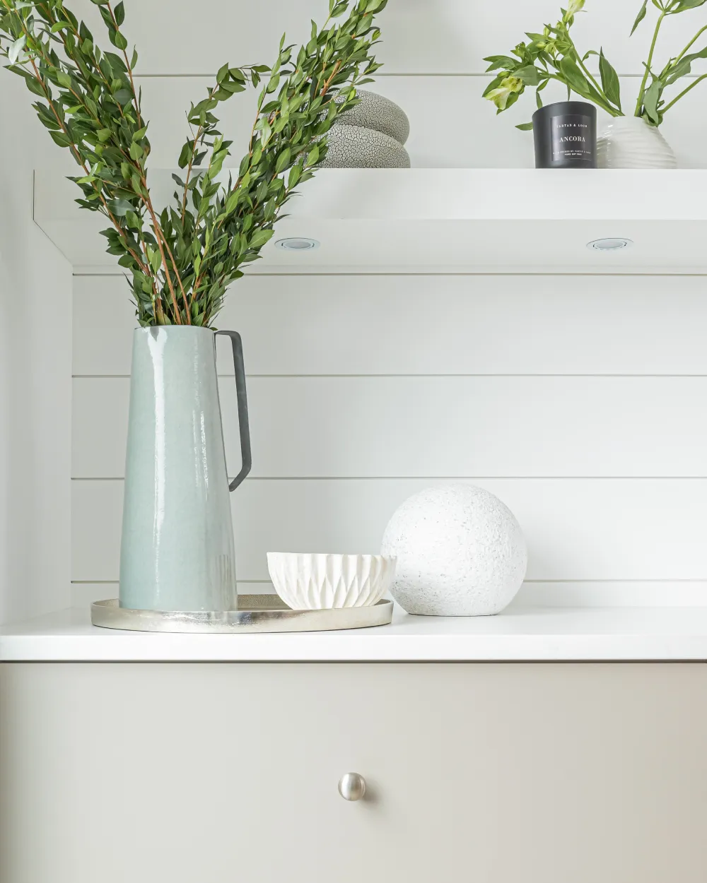Minimalist home décor with green plant vase and modern shelving showcasing home renovations White Rock by Bowline Construction in White Rock, BC