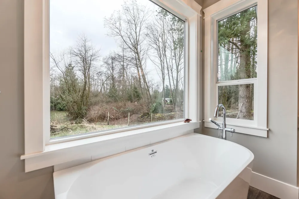 Modern bathroom with soaking tub and large windows showcasing home renovations White Rock by Bowline Construction in White Rock, BC