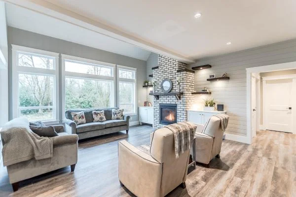 Modern living room renovation featuring white brick fireplace and cozy furnishings by Bowline Construction in White Rock, BC