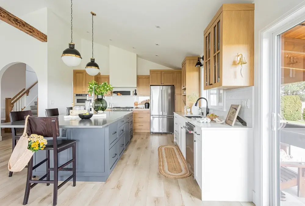 Modern kitchen with oak cabinets, gray island, stainless appliances; secondary suite cost Langley BC factors by Bowline Construction in Langley, BC