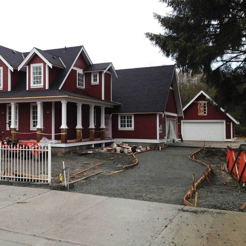 New home and detached garage under construction on a residential street for small-scale multi-unit housing in Langley, BC by Bowline Construction